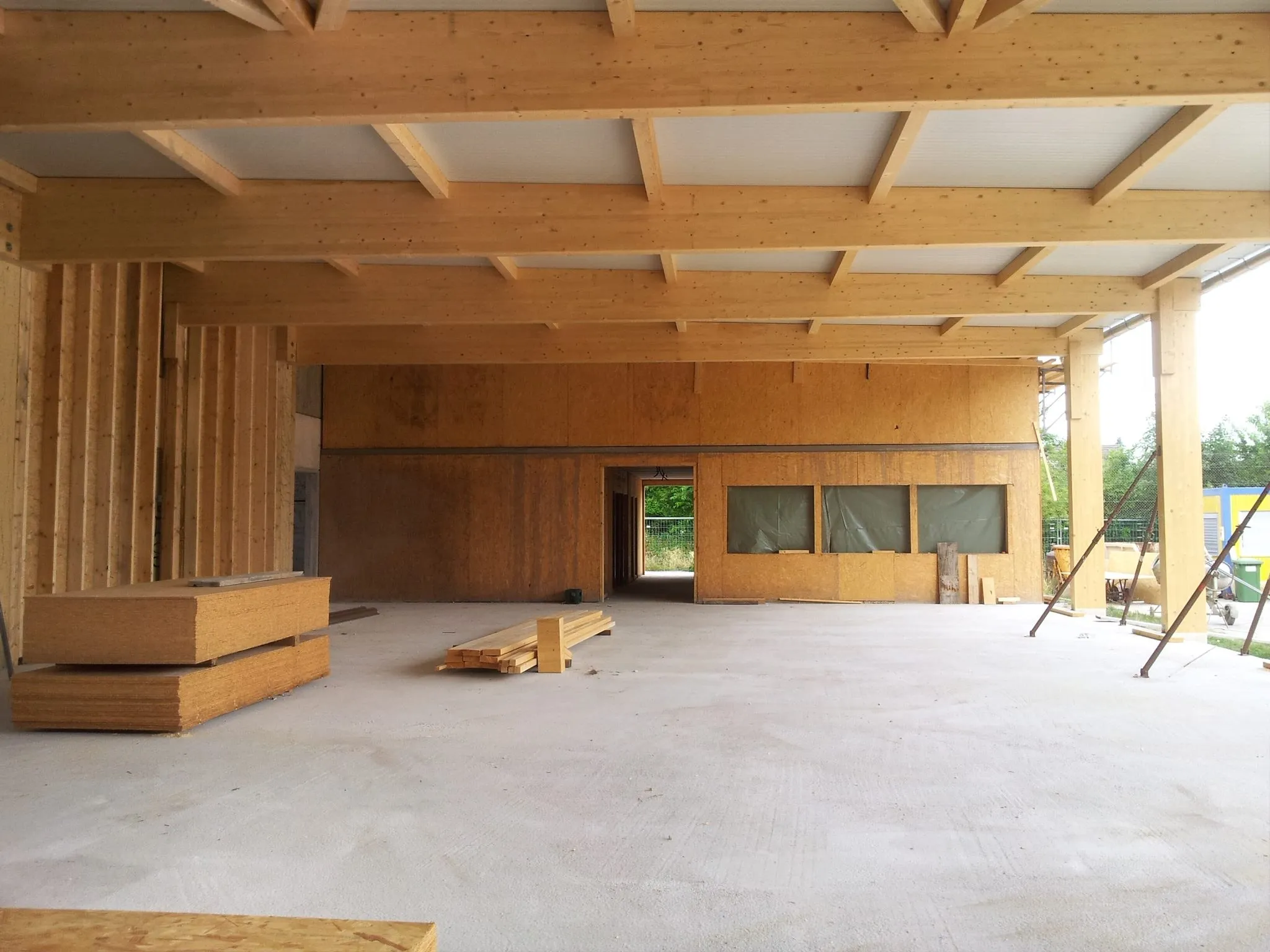 Die Halle innen fertig verkleidet, mit Fensterband und Durchgang, der Boden noch leer