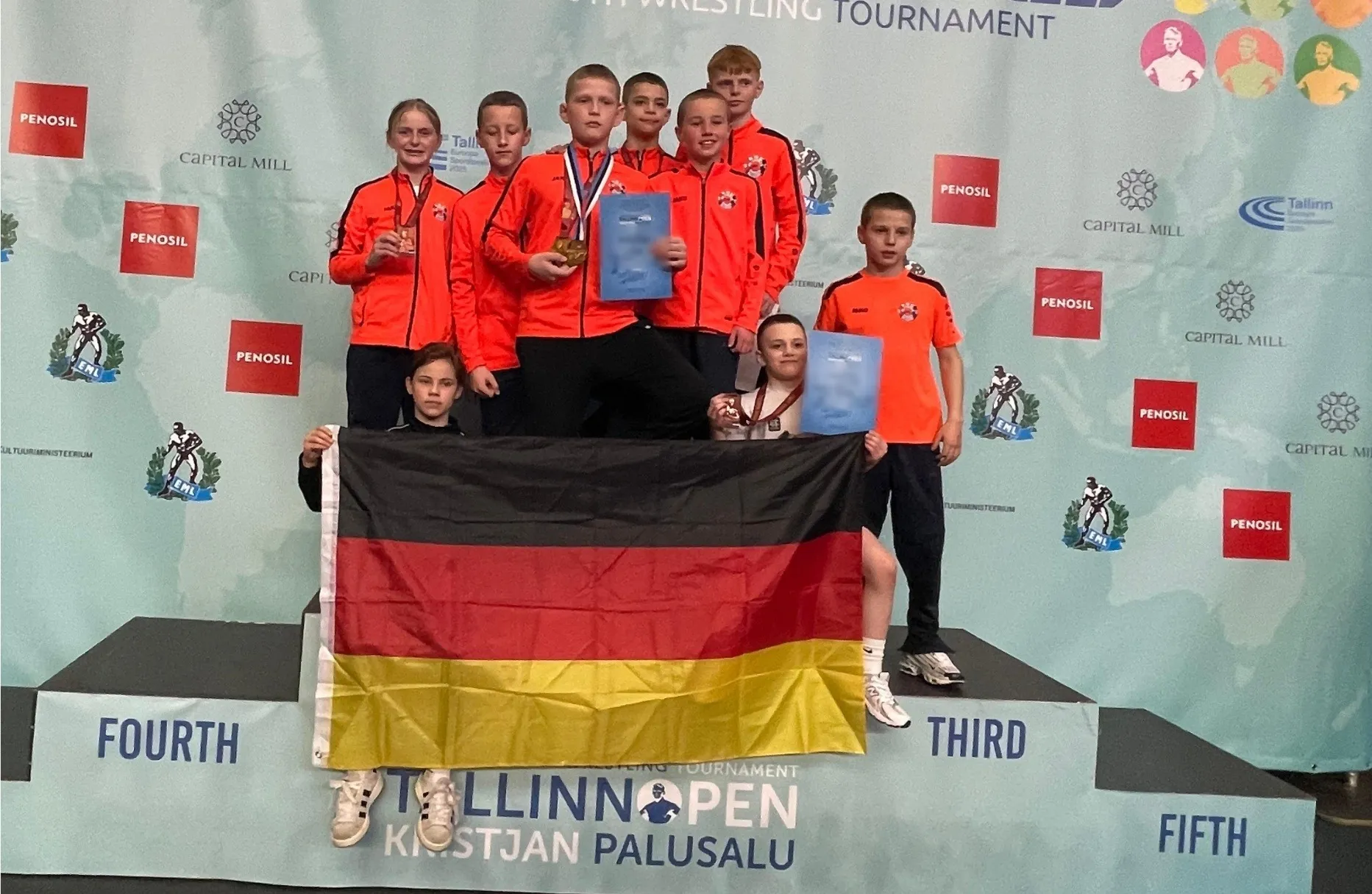 Die Mannschaft des KSC Graben-Neudorf auf dem Podest des Tallinn Open, davor eine ausgebreitete Deutschlandflagge